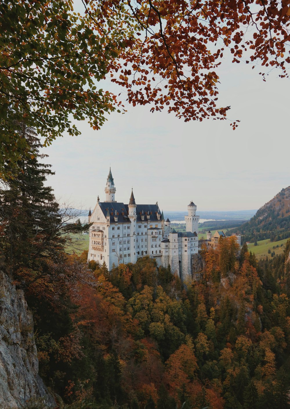 a large white castle sitting on top of a lush green hillside