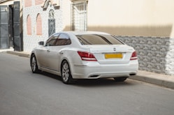 White luxury sedan with gleaming chrome details on a clean city square