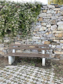 Low stone wall doubling as informal seating in a vibrant garden space.