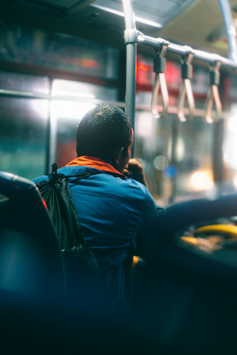 a man sitting on a bus looking out the window