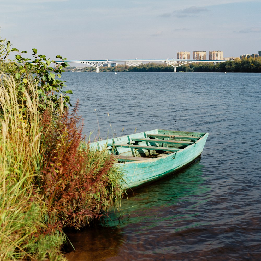 a small blue boat sitting on top of a lake