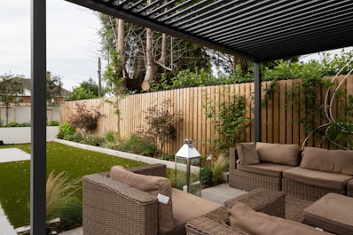 A modern patio design with elegant furniture and surrounding greenery.
