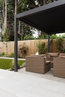 a covered patio with a couch and chairs