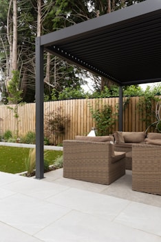 a covered patio with a couch and chairs