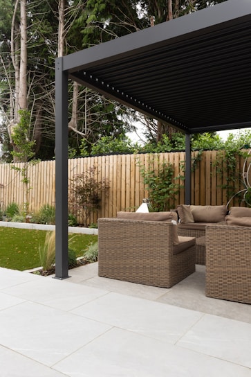 a covered patio with a couch and chairs