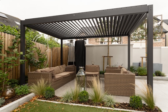 A modern pergola tent installed on a sunny terrace with comfortable seating.