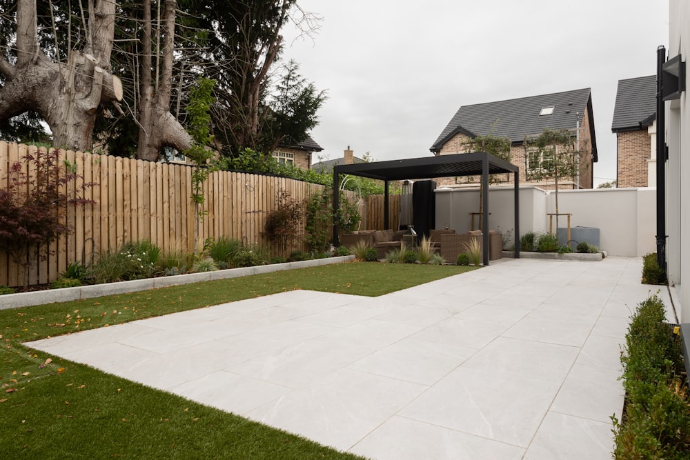 a backyard with a fence, grass and trees