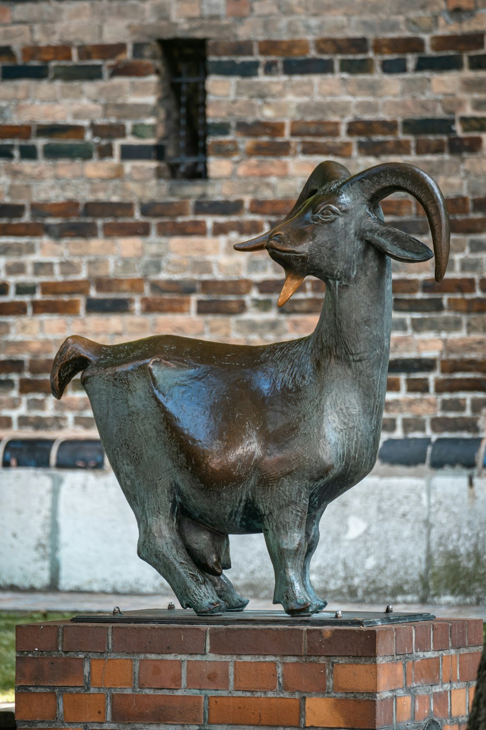 a statue of a ram on top of a brick wall