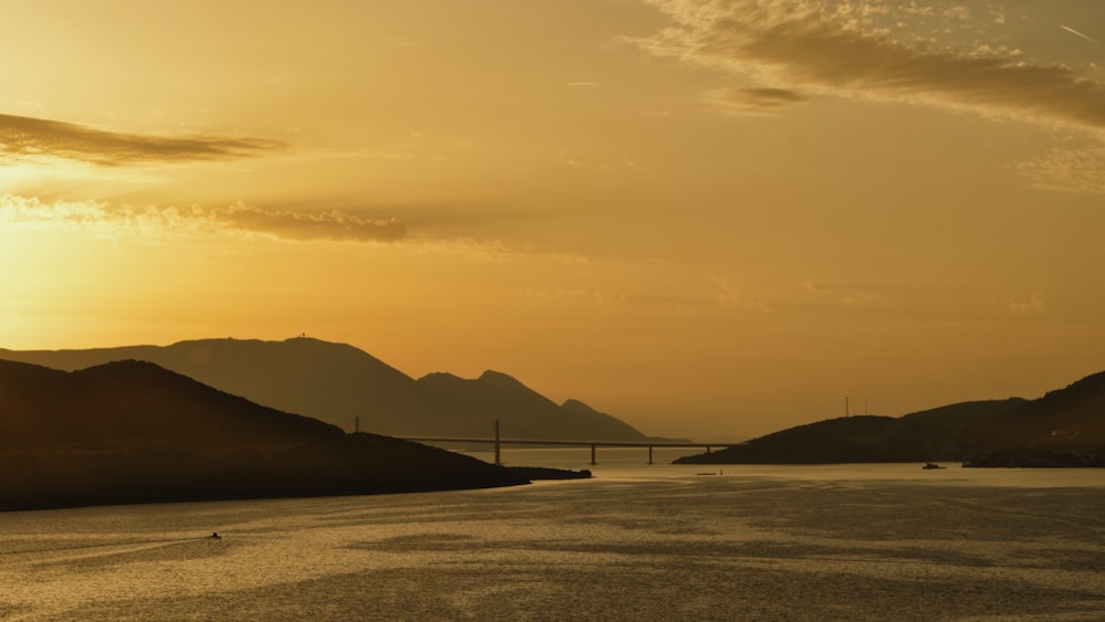 a large body of water with a bridge in the background