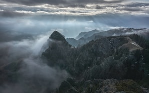 A misty morning view of the Smoky Mountains with sun rays piercing through the fog.