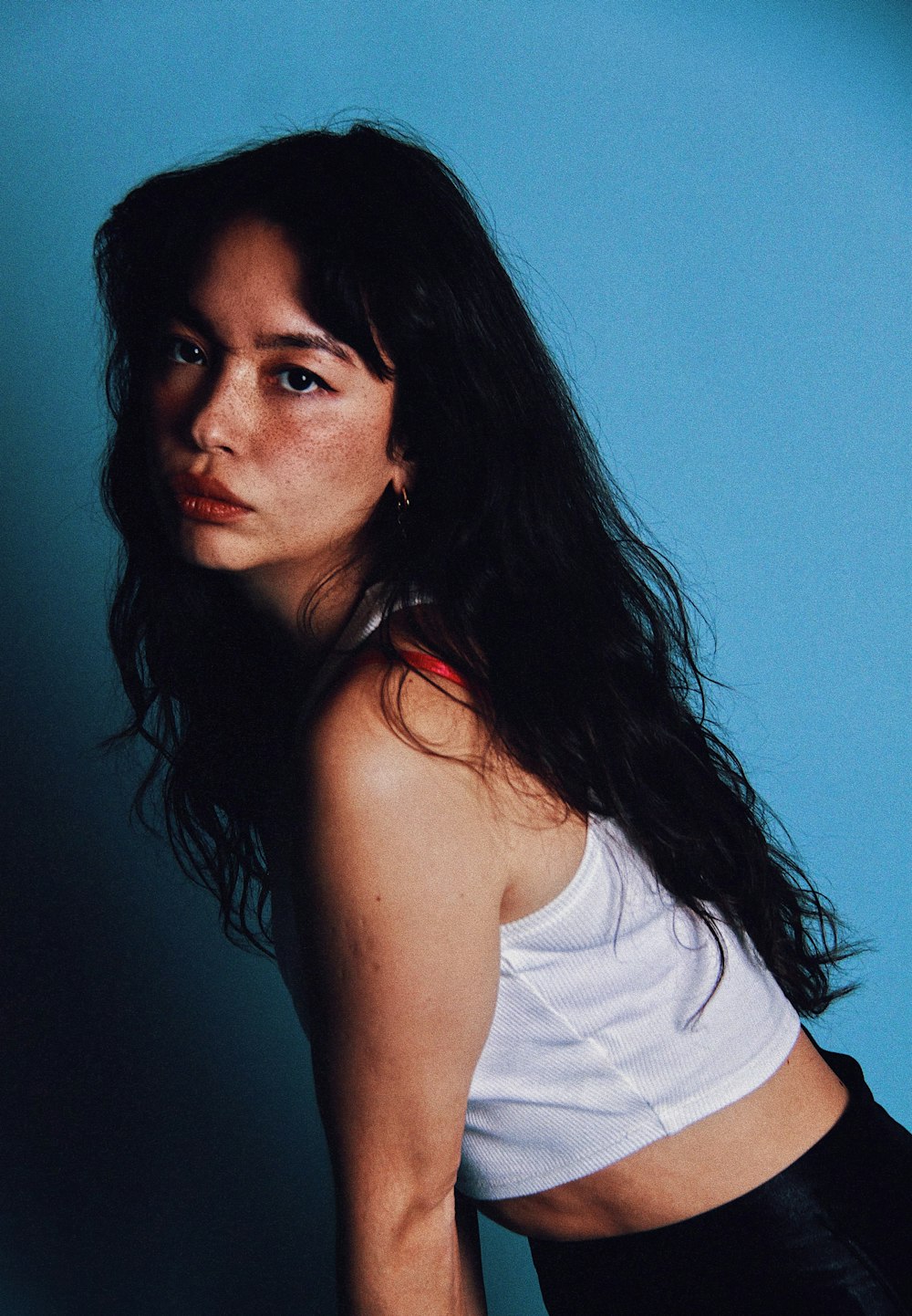 a woman in a white tank top posing for a picture