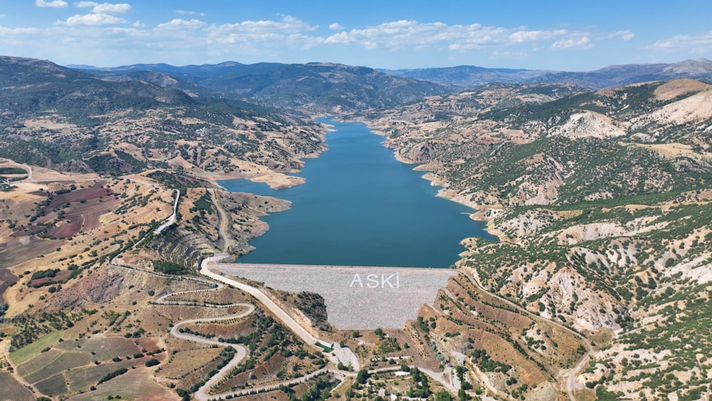 an aerial view of a lake surrounded by mountains