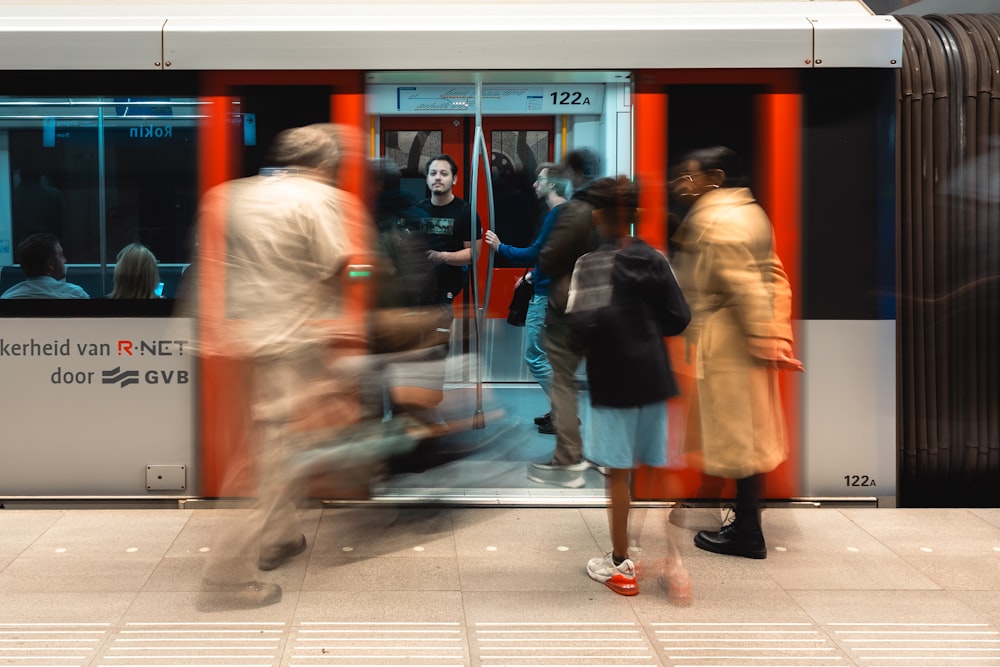 a group of people standing outside of a train