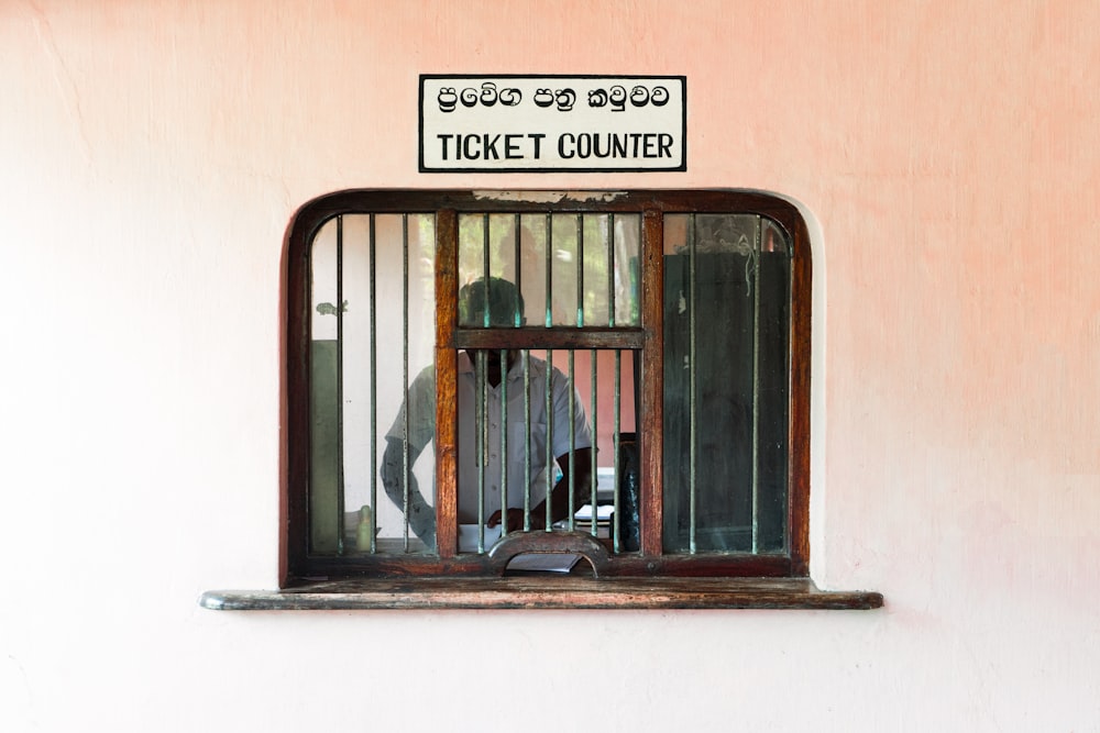 a man in a jail cell looking out the window