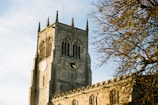 The iconic university clock tower standing tall against a clear blue sky.
