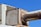 A large, rusted metal duct system against a clear blue sky. The structure includes rectangular and cylindrical sections showing significant signs of rust and weathering. The metal appears aged and worn, adding a rugged, industrial feel to the image.