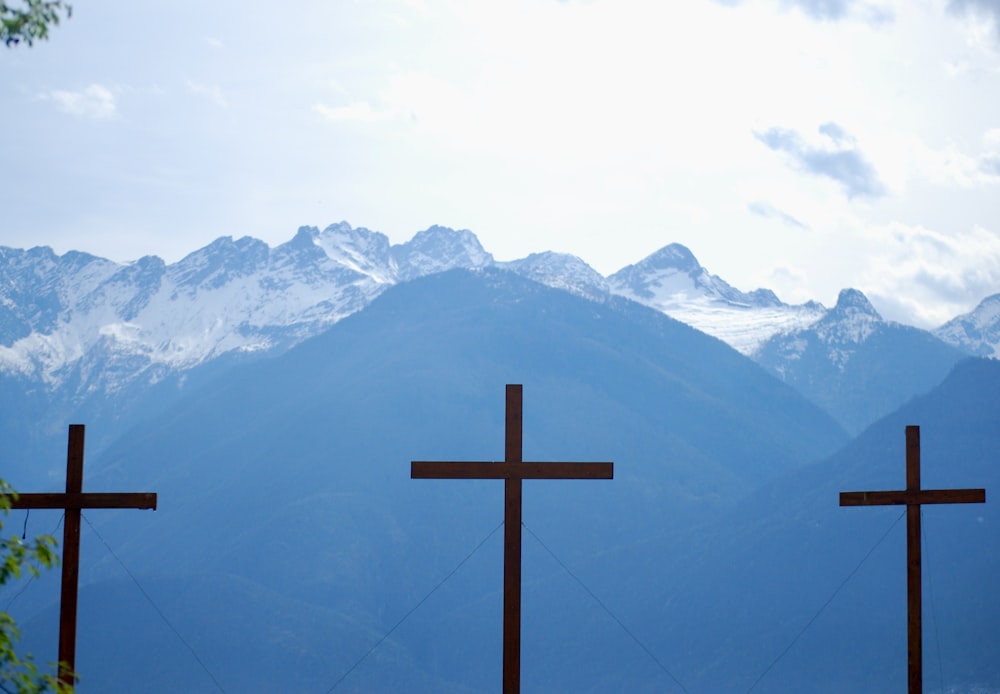 three crosses in front of a mountain range