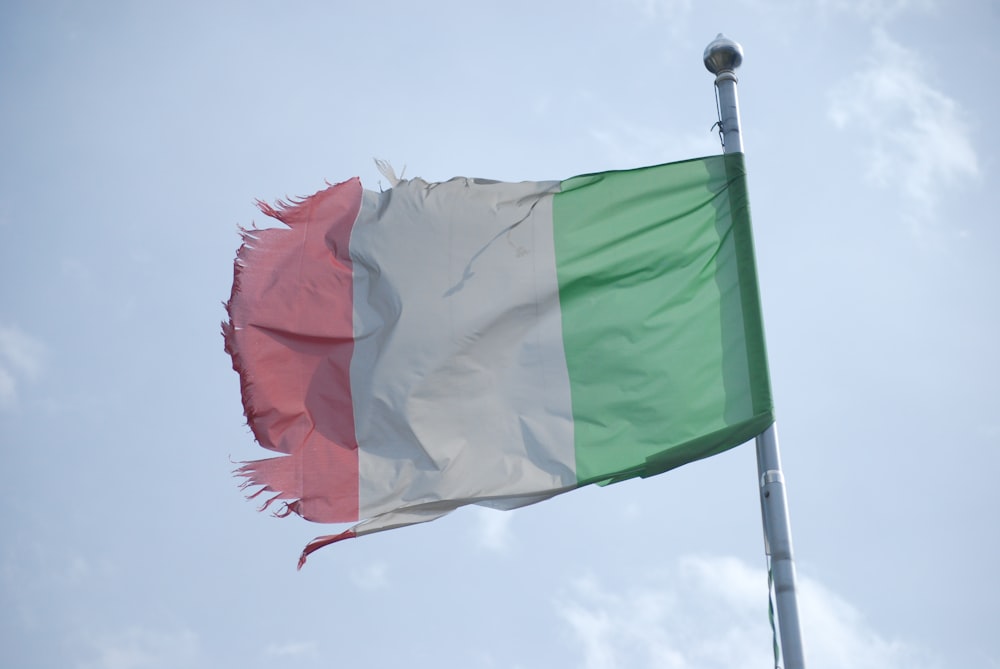 a flag flying in the wind with a sky background