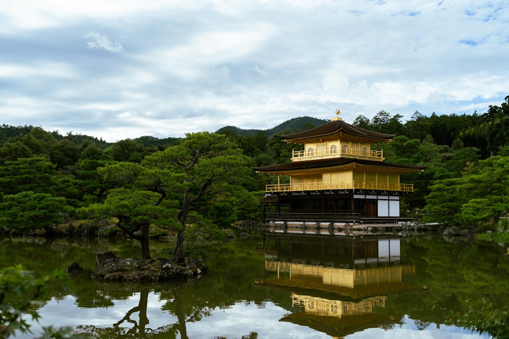 a building sitting on top of a lake surrounded by trees