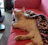 A cute cat lounging on a cozy sofa wearing a stylish, handmade pink hoodie.