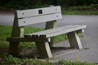 a wooden bench sitting on the side of a road