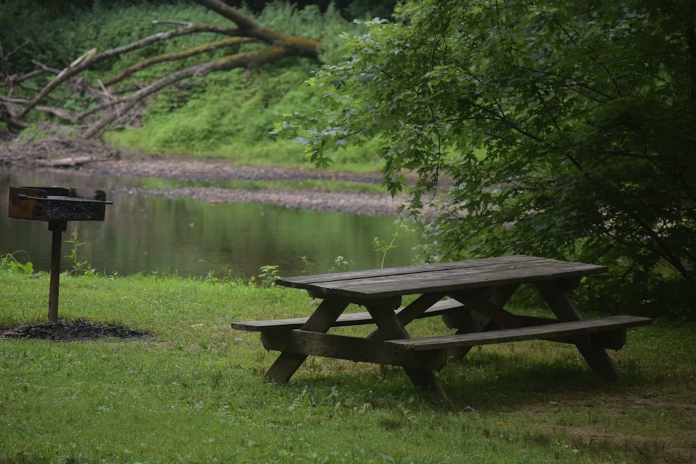 a picnic table sitting in the grass next to a lake