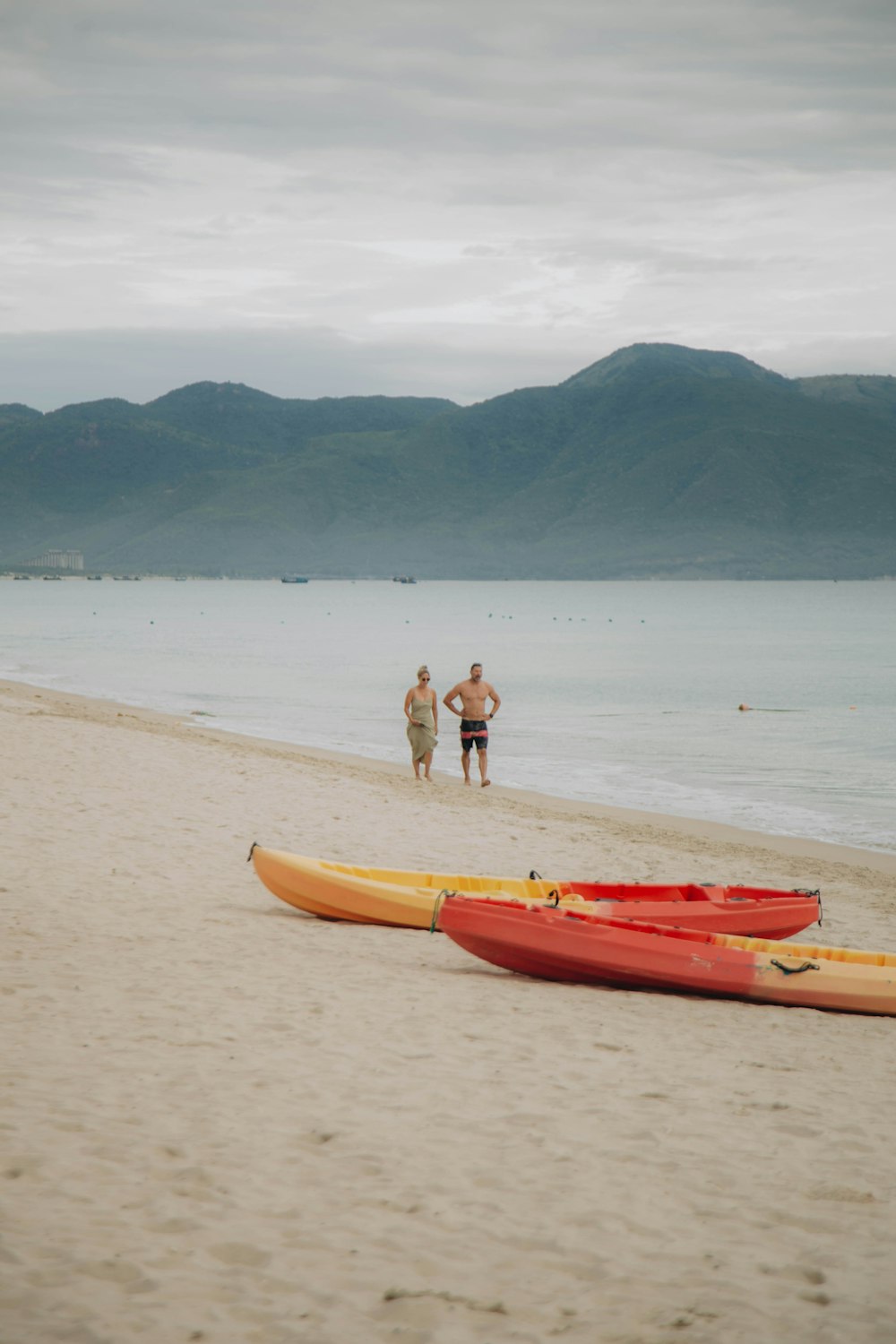 a couple of kayaks sitting on top of a sandy beach