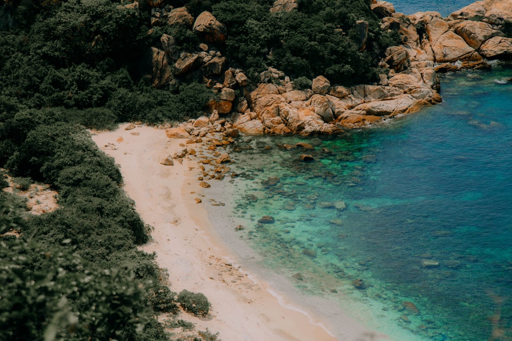 an aerial view of a beach with clear blue water