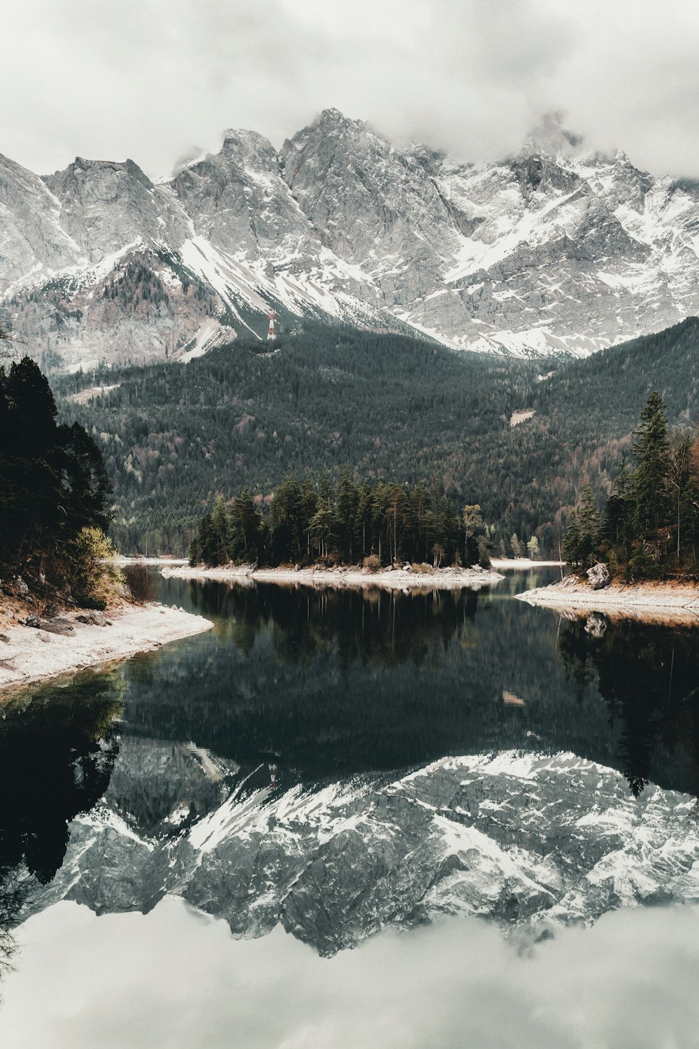 a body of water surrounded by snow covered mountains