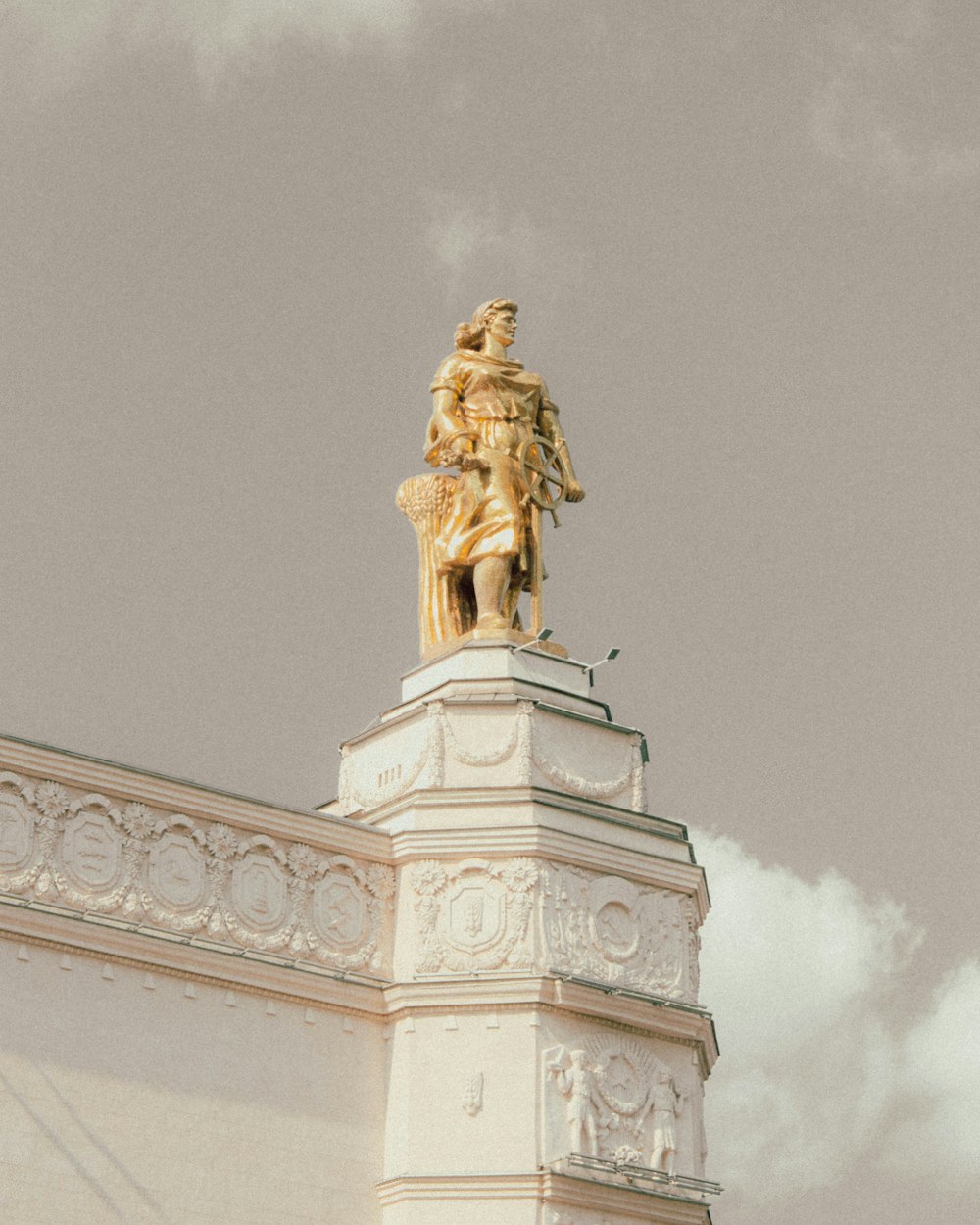 a golden statue on top of a white building