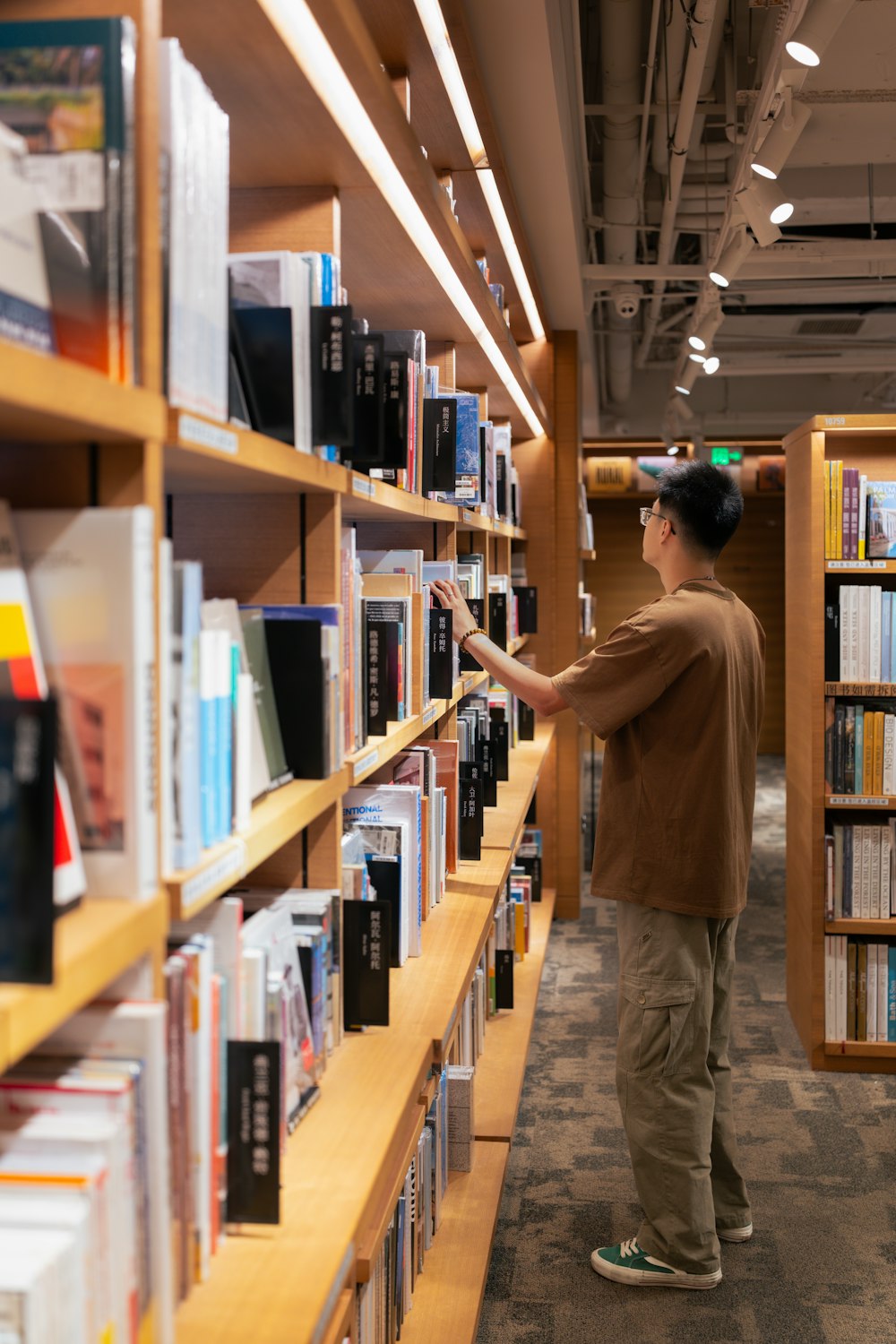 a man standing in front of a book shelf filled with books