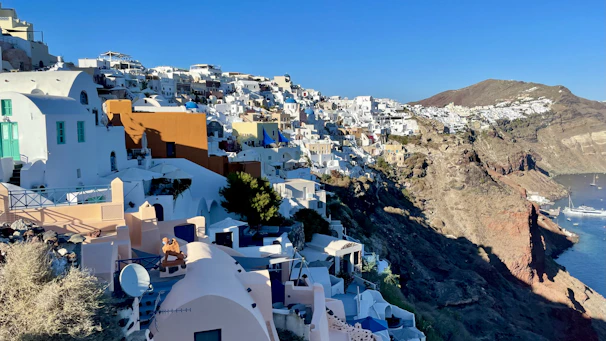 Charming whitewashed houses perched on a cliffside overlooking the deep blue Mediterranean Sea.