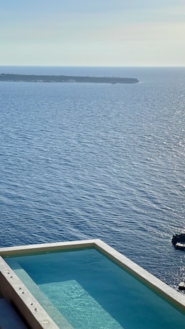A luxury resort infinity pool blending seamlessly with the turquoise sea beyond.