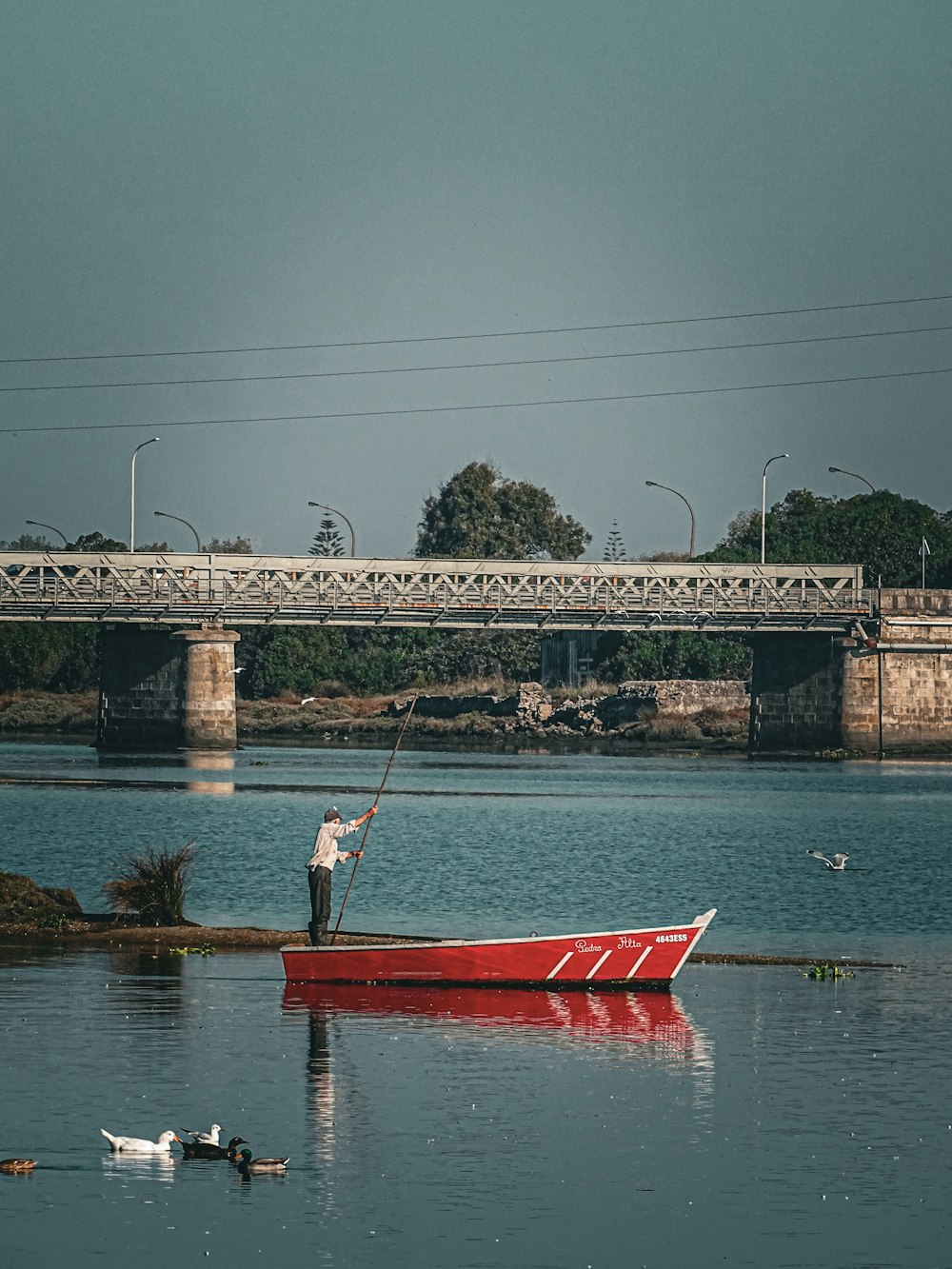 a man standing on a boat in the middle of a lake