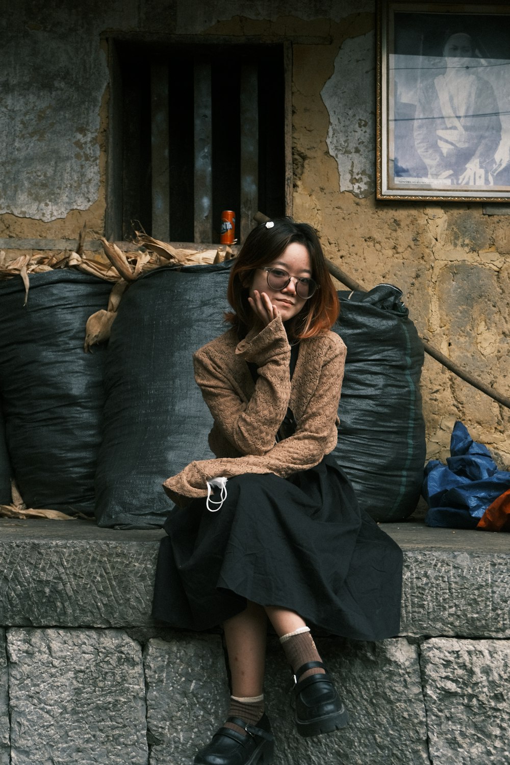 a woman sitting on a ledge in front of a building