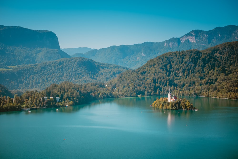 a small island in the middle of a lake surrounded by mountains