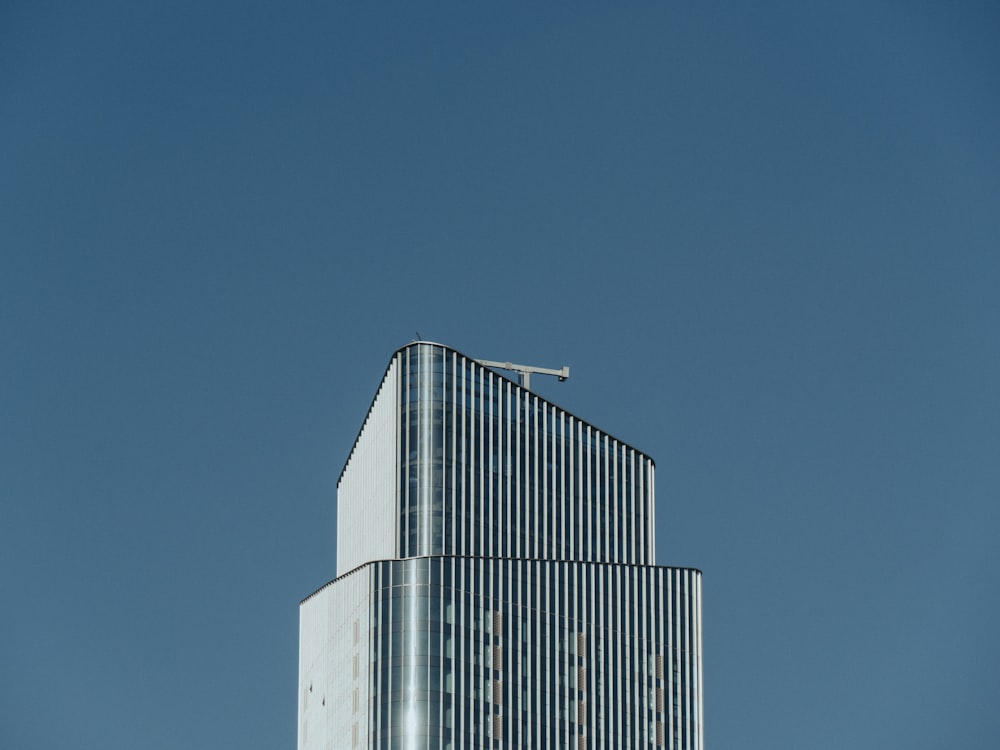 Un edificio alto con un aereo che vola nel cielo