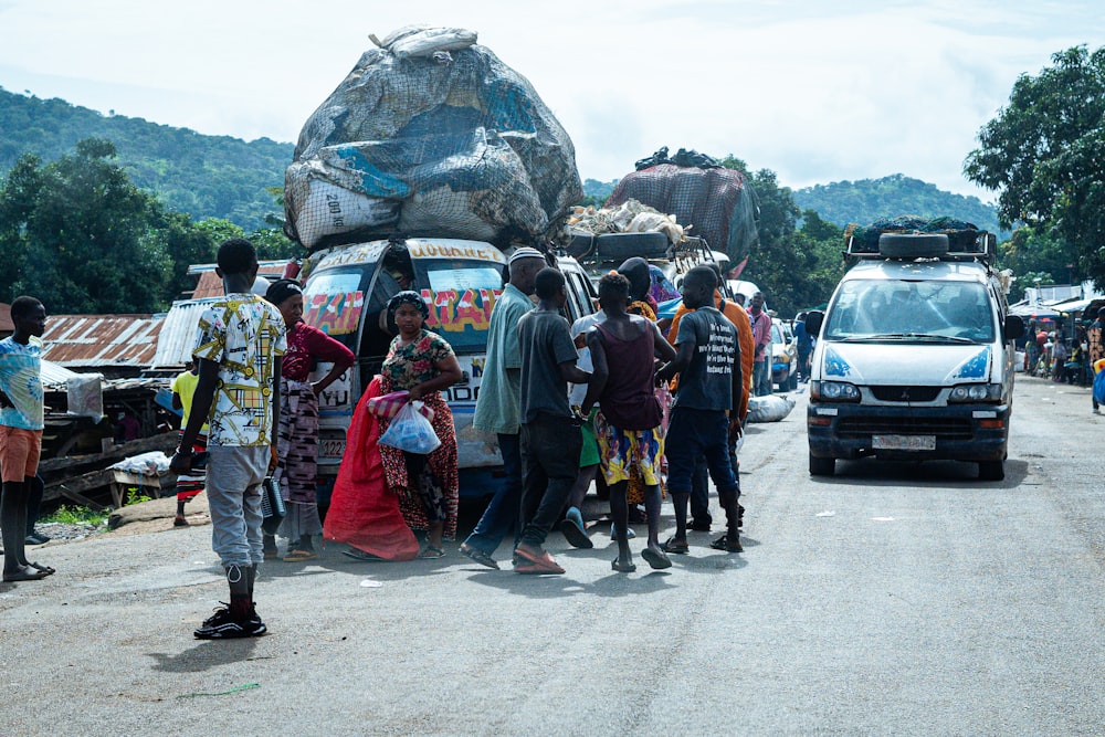 a group of people standing on the side of a road