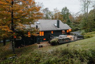 A cozy prefab park home nestled among trees at sunset, showcasing its warm, inviting design.