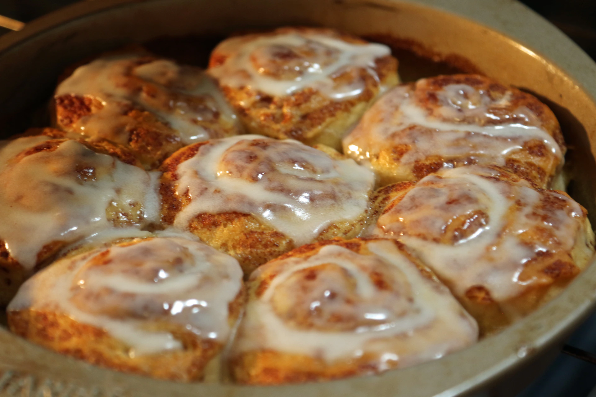 a pan filled with cinnamon rolls covered in icing