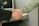A professional handshake between two people in a modern office setting.