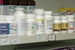 High-cost medications arranged on a pharmacy shelf.