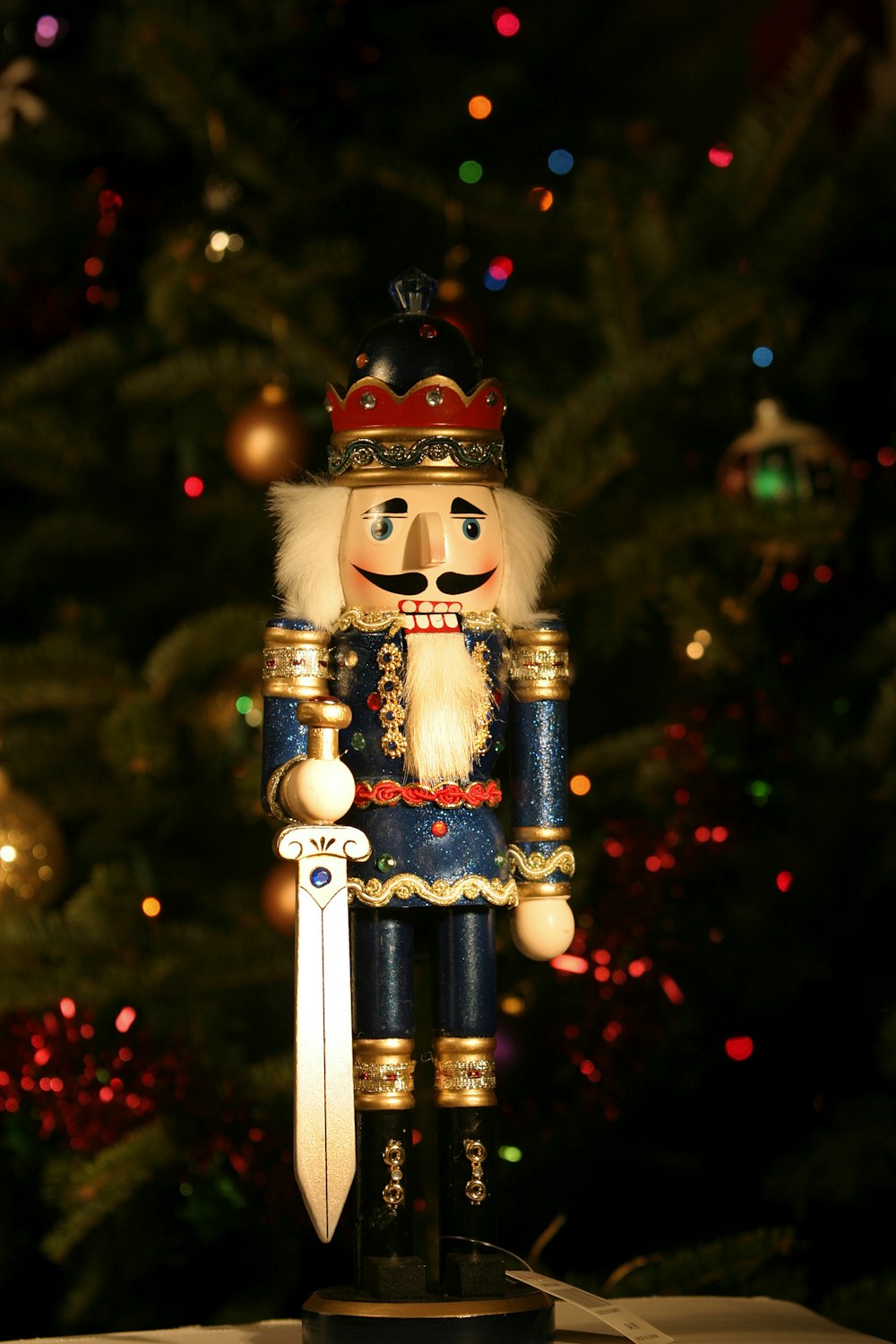 a nutcracker figurine stands in front of a christmas tree