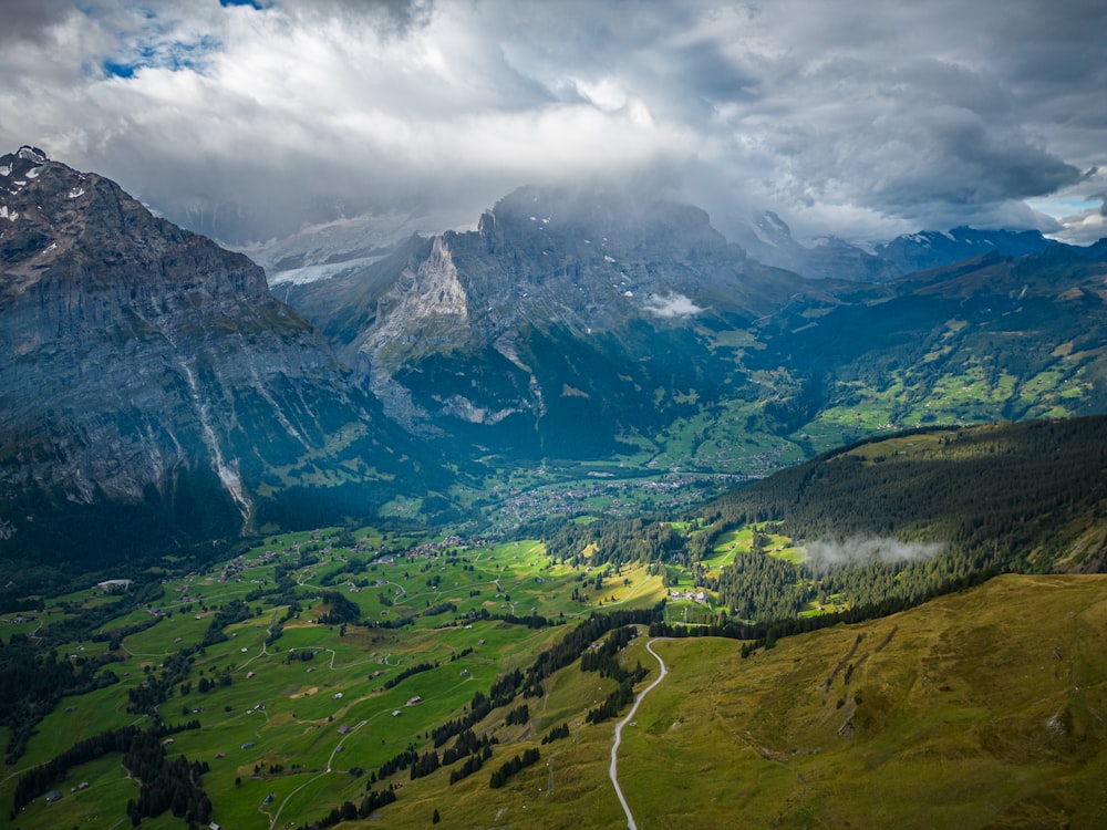 a scenic view of a valley with mountains in the background