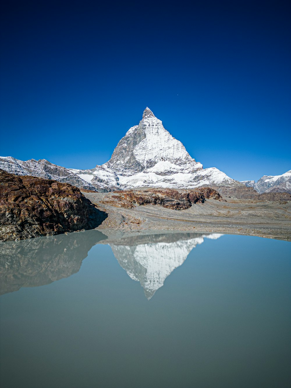 a mountain is reflected in the still water of a lake