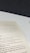 A close-up view of an open book page showing text on a desk or table. The text contains several sections with headers such as 'The Origins of Scrum' and various advice points, including observe, orient, decide, and act. The surface underneath the book is white with a dark background.