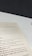 A close-up view of an open book page showing text on a desk or table. The text contains several sections with headers such as 'The Origins of Scrum' and various advice points, including observe, orient, decide, and act. The surface underneath the book is white with a dark background.