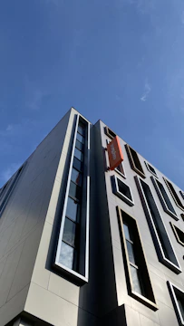 Wide shot of a commercial building freshly painted in white and orange accents.
