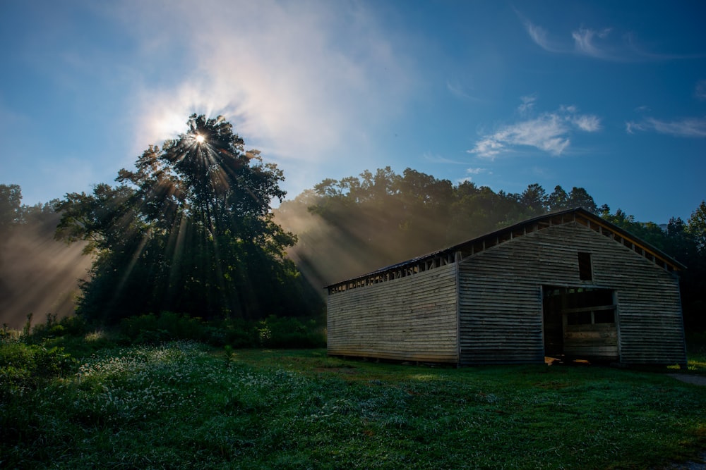 the sun shines through the clouds over a barn