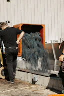 a man standing next to a machine making something blue